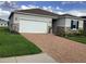 Exterior of a beautiful home featuring a brick driveway and a well-maintained front lawn at 12630 Aston Dr, Hudson, FL 34669