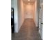 Hallway with tile flooring leads to a bright entrance and rooms throughout the house at 12630 Aston Dr, Hudson, FL 34669