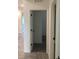 Hallway view into carpeted bedroom with neutral walls and base trim at 12630 Aston Dr, Hudson, FL 34669
