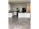 Modern kitchen with sleek black appliances, white cabinetry, and granite countertops at 12630 Aston Dr, Hudson, FL 34669