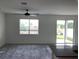 Bright living room with neutral walls, ceiling fan, and sliding doors to the backyard at 12630 Aston Dr, Hudson, FL 34669