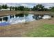 Scenic view of a pond reflecting the sky, with young trees planted along the bank at 12630 Aston Dr, Hudson, FL 34669
