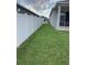 Large grassy side yard with a secure white vinyl fence, leading to the garage at 12630 Aston Dr, Hudson, FL 34669