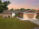 Charming single-story home featuring a well-maintained lawn, tan exterior, and attached two-car garage at 12709 Cedar Ridge Dr, Hudson, FL 34669