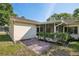 Backyard showing the home and inviting screened-in patio with lush green landscaping at 12906 Sandburst Ln, Hudson, FL 34667