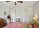 Cozy bedroom featuring hardwood floors, a ceiling fan, and a convenient closet for easy storage at 12906 Sandburst Ln, Hudson, FL 34667