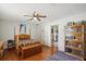 Cozy bedroom with a four-poster bed, ceiling fan, and natural light at 12906 Sandburst Ln, Hudson, FL 34667