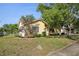 Quaint home featuring a lush lawn, mature trees, and an attached garage at 12906 Sandburst Ln, Hudson, FL 34667