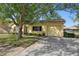 Lovely home featuring a well-manicured lawn, mature trees, and a garage at 12906 Sandburst Ln, Hudson, FL 34667