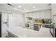Well-lit kitchen with stainless steel appliances and white countertops offering a clean and modern feel at 12906 Sandburst Ln, Hudson, FL 34667