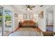 Cozy living room with a comfortable sofa, ceiling fan, and access to the outdoors at 12906 Sandburst Ln, Hudson, FL 34667