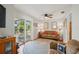 Comfortable living room with a cozy sofa, ceiling fan, and access to an enclosed porch at 12906 Sandburst Ln, Hudson, FL 34667