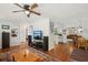Inviting living room featuring hardwood floors and an entertainment center, seamlessly flowing into other living spaces at 12906 Sandburst Ln, Hudson, FL 34667