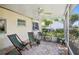 Outdoor screened patio with comfortable seating and a ceiling fan for a pleasant outdoor experience at 12906 Sandburst Ln, Hudson, FL 34667