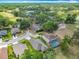 Aerial view of homes featuring mature landscaping, a screened pool and golf course in the background at 13111 Precept Way, Hudson, FL 34669