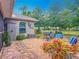 Paved backyard with comfortable seating, outdoor cooking area, lush landscaping, and a serene view at 13111 Precept Way, Hudson, FL 34669