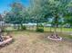 Spacious backyard featuring lush green grass, mature trees, and a wrought iron fence for privacy at 13111 Precept Way, Hudson, FL 34669