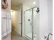 Bright bathroom featuring a glass shower, nautical decor and gray tile flooring at 13111 Precept Way, Hudson, FL 34669
