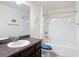 Well-lit bathroom with a sink vanity, mirror, and tiled shower-tub combination at 13111 Precept Way, Hudson, FL 34669