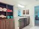 Bathroom featuring a double sink vanity, large mirror, and dark wood linen closet at 13111 Precept Way, Hudson, FL 34669