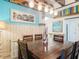 Bright dining room with colorful walls, wood table with seating, wooden paneling, and decorative lighting at 13111 Precept Way, Hudson, FL 34669