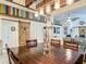 Open-concept dining room featuring barn doors, colorful accents, and a spacious wood table for entertaining at 13111 Precept Way, Hudson, FL 34669