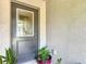Charming front door with decorative glass and textured exterior siding, accented by plants at 13111 Precept Way, Hudson, FL 34669