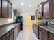 Modern kitchen showcasing dark wood cabinets, stainless steel appliances, mosaic backsplash, and functional layout at 13111 Precept Way, Hudson, FL 34669