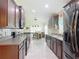 Bright kitchen featuring stainless steel appliances, dark wood cabinets, and an open design to the dining area at 13111 Precept Way, Hudson, FL 34669