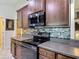 Updated kitchen highlighting dark wood cabinetry, stainless steel appliances, mosaic backsplash, and modern design at 13111 Precept Way, Hudson, FL 34669