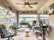 Cozy screened patio with comfortable seating, plants, and a ceiling fan for relaxing in an outdoor living space at 13111 Precept Way, Hudson, FL 34669