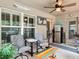 Cozy screened patio with comfortable seating, stylish decor, mini refrigerator, and a fan for relaxing in the backyard at 13111 Precept Way, Hudson, FL 34669