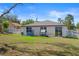 View of the backyard featuring a trampoline, playhouse, and sliding glass door entrance at 13205 Arkendale St, Spring Hill, FL 34609