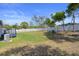 Spacious backyard with a white picket fence, lush green grass, and mature trees at 13205 Arkendale St, Spring Hill, FL 34609