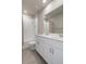 Bright bathroom featuring double sink vanity, a large mirror, a showerhead, and white tiled walls in the shower at 13205 Arkendale St, Spring Hill, FL 34609