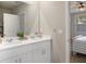 Bright bathroom boasts a double vanity with white cabinets, quartz counters, and large mirror at 13205 Arkendale St, Spring Hill, FL 34609