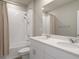 Bright bathroom featuring double sink vanity, a large mirror, a showerhead, and white tiled walls in the shower at 13205 Arkendale St, Spring Hill, FL 34609