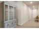 Hallway with decorative cabinet, neutral walls, and tile flooring, leading to the front door at 13205 Arkendale St, Spring Hill, FL 34609