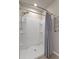 Modern shower stall featuring curved walls, built-in shelving, sleek fixtures, and a contemporary shower curtain at 13205 Arkendale St, Spring Hill, FL 34609