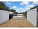 Gated area of gravel parking with privacy fence, covered boat, and outdoor equipment at 13373 Lawrence St, Spring Hill, FL 34609