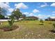 Spacious backyard featuring a lush lawn, mature trees, and a white fence, perfect for outdoor activities at 13373 Lawrence St, Spring Hill, FL 34609