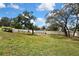 Expansive backyard with a well-maintained lawn, mature trees, and white fencing, creating a private outdoor space at 13373 Lawrence St, Spring Hill, FL 34609