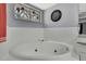 Close up of luxurious soaking tub with jets, decorative window, and tiled surround at 13373 Lawrence St, Spring Hill, FL 34609