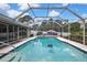 Clean swimming pool with a screened enclosure and view of the home at 13373 Lawrence St, Spring Hill, FL 34609