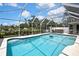 Beautiful screened-in pool with clear blue water and patio furniture for relaxing and entertaining at 13373 Lawrence St, Spring Hill, FL 34609