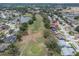 Aerial view showcasing a picturesque neighborhood featuring golf course, and a serene lake at 13524 Knotty Ln, Hudson, FL 34669