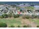 Panoramic aerial view of a residential area featuring a nearby golf course and several lakes at 13524 Knotty Ln, Hudson, FL 34669