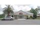 Welcoming clubhouse exterior with a neatly landscaped front, car parked, and inviting entrance at 13524 Knotty Ln, Hudson, FL 34669