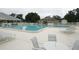 Inviting community pool area with lounge chairs and tables for residents to enjoy the sun at 13524 Knotty Ln, Hudson, FL 34669
