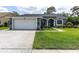 Well maintained single story home boasts a two-car garage, lush lawn and attractive landscaping at 13524 Knotty Ln, Hudson, FL 34669